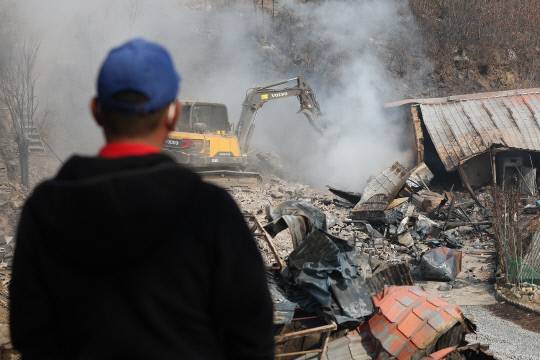 경북 의성군 대형 산불 발생 이틀째인 23일 의성군 안평면의 한 주택이 산불로 전소된 가운데 철거작업이 진행되고 있다. 연합뉴스
