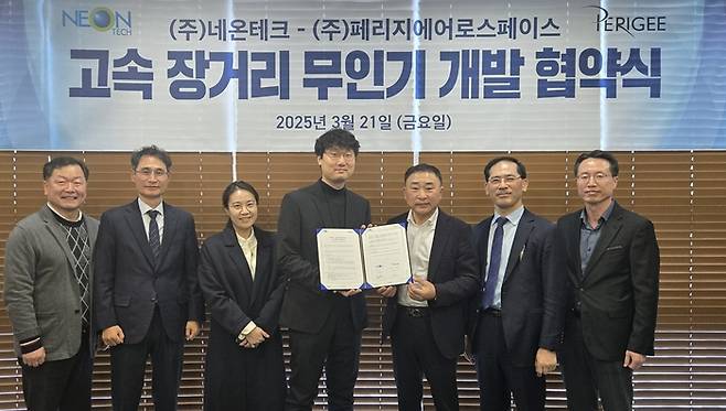 황성일 네온테크 회장(오른쪽 세 번째)이 신동윤 페리지에어로스페이스 대표(〃 네 번째)와 지난 21일 네온테크 경기도 안양 사옥에서 '고속 장거리 무인기 개발 협약서'를 교환하며 기념 촬영했다. [사진:네온테크]