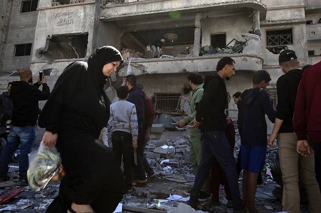 2025년 3월19일 팔레스타인 땅 가자지구 북부 가자시티에서 주민들이 이스라엘군의 공습으로 파괴된 건물을 살피고 있다. EPA 연합뉴스
