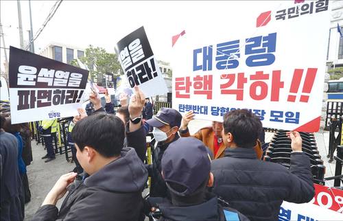 지난 3월 20일 서울 종로구 헌법재판소 앞에서 열린 더불어민주당 의원에 대한 계란 투척 사건 관련 규탄 기자회견에서 윤석열 대통령 탄핵 촉구 피켓을 든 관계자와 탄핵 각하 피켓을 든 국민의힘 지지자가 각자의 피켓을 들고 있다. (연합뉴스)