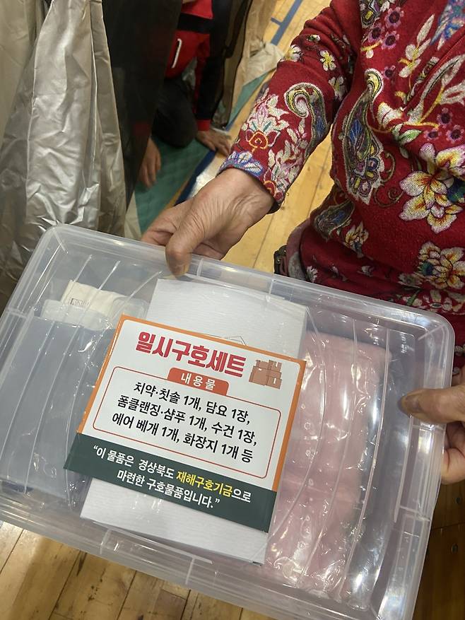 경북 의성군 산불 이재민을 위한&nbsp;임시대피소가 차려진 의성체육관에서 만난 주민이 구호 세트를 직접 보여주고 있다.