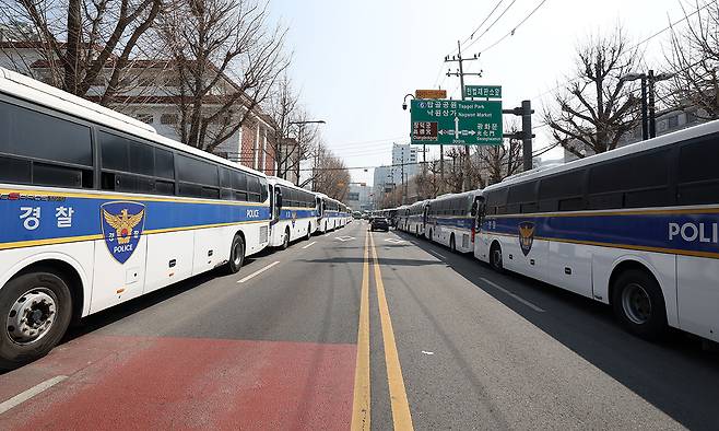 한덕수 국무총리의 탄핵 심판 사건 선고를 하루 앞둔 23일 서울 종로구 헌법재판소 인근에 경찰 기동대 버스가 길게 배치되어 있다. 뉴시스