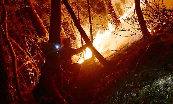 22일 전날 경남 산청에서 발생한 산불이 산등성이를 타고 확산되고 있는 가운데 산림청 소속 공중진화대가 산불을 진화하고 있다. 뉴시스