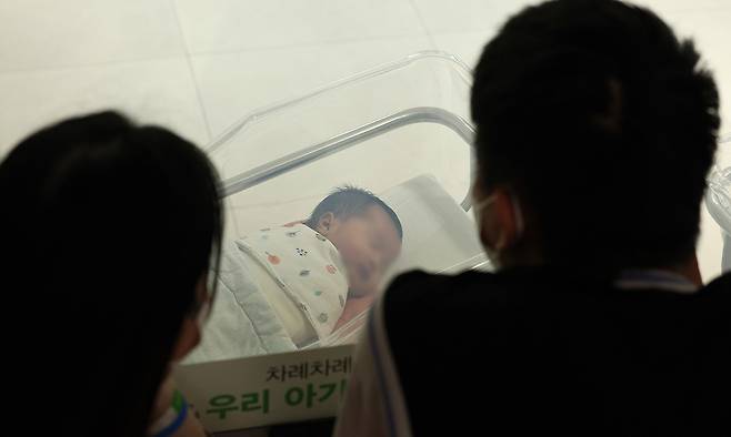 인천의 한 병원 신생아실에서 가족이 아이를 바라보고 있다. 뉴스1