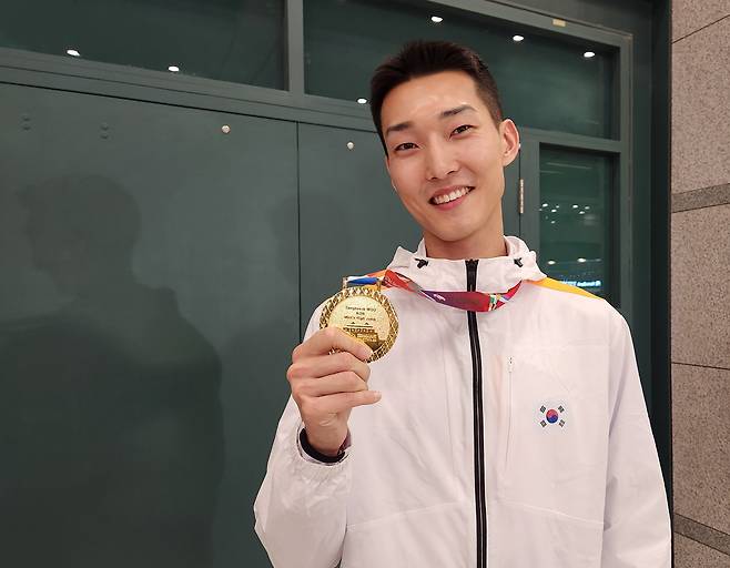 2025 난징 세계실내선수권대회에서 금메달을 차지한 ‘스마일 점퍼’ 우상혁이 22일 인천국제공항을 통해 귀국한 뒤 메달을 들어 보이고 있다.  연합뉴스