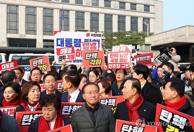 여야, 헌재 앞 '윤 대통령 탄핵 찬반' 맞불 기자회견 (서울=연합뉴스) 김도훈 기자 =  지난 21일 서울 종로구 헌법재판소 앞에서 윤석열 대통령 탄핵 각하 촉구 기자회견을 준비하던 국민의힘 의원들(앞쪽)이 윤 대통령 즉각 파면 촉구 기자회견을 하는 더불어민주당 의원들(뒤쪽)을 바라보고 있다. 2025.3.21 superdoo82@yna.co.kr