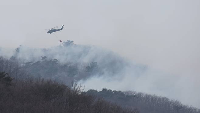 울산 울주군 온양읍 산불 사흘째인 24일 진화 작업에 동원된 헬기가 물을 뿌린 후 선회하고 있다. /연합뉴스