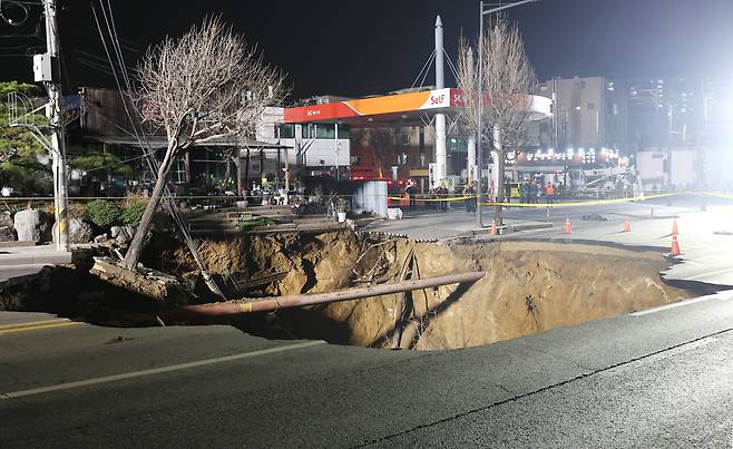 24일 오후 6시 29분쯤 싱크홀(땅 꺼짐) 사고가 발생한 서울 강동구 대명초등학교 인근 사거리에서 소방대원들이 현장 수색 및 구조작업을 준비하고 있다. /연합뉴스