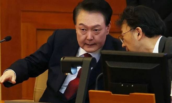 윤석열 대통령이 지난 1월21일 헌법재판소에서 열린 탄핵심판 3차 변론기일에 출석해 차기환 변호사와 대화하고 있다. 사진공동취재단