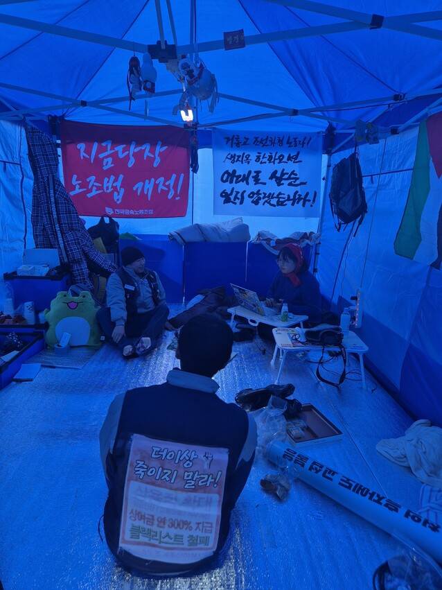 김형수 거제·통영·고성 조선하청지회장이 고공농성 중인 서울 중구 한화 본사 앞 농성장에서 조합원들과 ’말벌 동지’들이 함께 이야기 나누고 있다. 신다은 기자