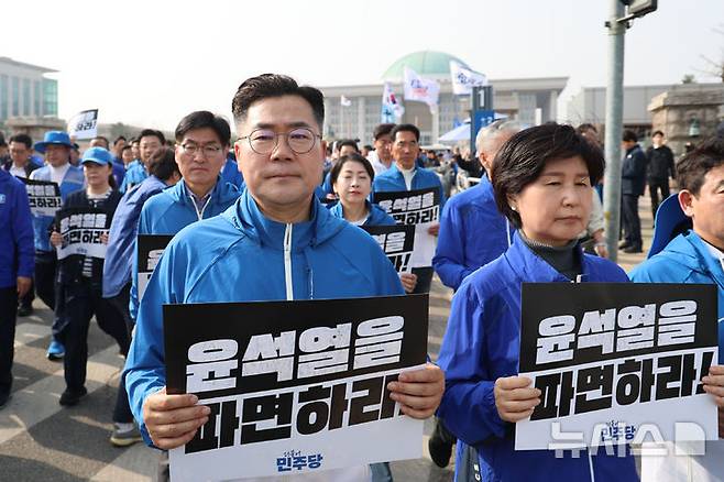 [서울=뉴시스] 권창회 기자 = 박찬대 더불어민주당 원내대표를 비롯한 의원들이 24일 오후 서울 여의도 국회에서 광화문 방향으로 윤석열 대통령 파면을 촉구하는 도보행진을 하고 있다. 2025.03.24. kch0523@newsis.com