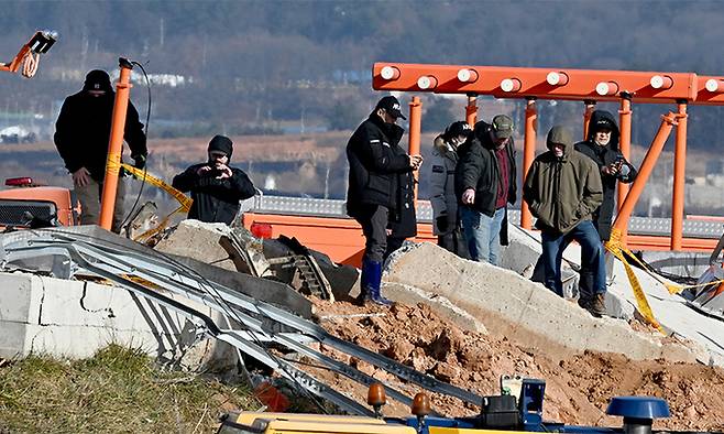 지난 2024년 12월 31일 전남 무안군 무안국제공항 제주항공 여객기 참사 현장에서 정부합동조사단이 로컬라이저(착륙유도시설) 둔덕에 올라 콘크리트 잔해 등을 살펴보고 있다. 뉴시스