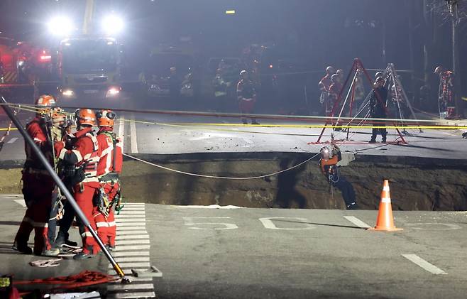 24일 싱크홀(땅 꺼짐) 사고가 발생한 서울 강동구 대명초등학교 인근 사거리에서 소방대원이 내부 구조 작업에 나서고 있다. 사진=연합뉴스