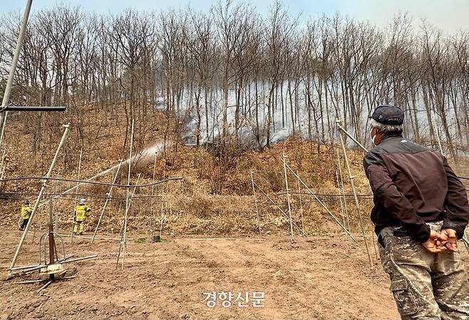 경북 안동시 길안면 백자리에서 25일 한 주민이 마을로 접근하고 있는 불길의 진압 작업을 지켜보고 있다. 백경열 기자