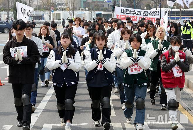 [서울=뉴시스] 김금보 기자 = 윤석열퇴진전국대학생시국회의 회원들이 25일 서울 종로구 광화문 월대 앞에서 헌법재판소 방향으로 윤석열 대통령 파면을 촉구하는 삼보일배 행진을 하고 있다. 2025.03.25. kgb@newsis.com