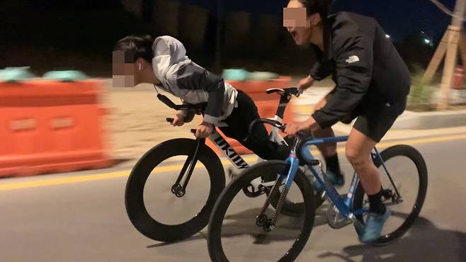 귀에 이어폰을 꽂고 헬멧을 착용하지 않은 채 픽시 자전거를 몰고 새벽 도로를 질주하고 있다. 이런 행위는 도로교통법 위반으로 처벌받을 수 있다. 헬멧 착용도 법으로 착용을 의무화하고 있다. 사진=유튜브 갈무리