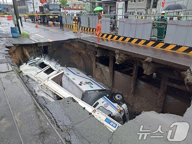 지난해 9월 21일 오전 8시45분께 부산 사상구 한 도로에서  싱크홀이 발생해 도로에서 배수 지원을 하던 삼락119안전센터 배수 차량과 5톤 트럭이 빠져있다. (부산소방재난본부 제공) 2024.9.21/뉴스1 ⓒ News1 윤일지 기자
