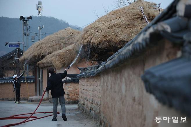 이날 오후 유네스코 세계유산인 안동 하회마을 관계자들이 산불이 번질 것에 대비해 초가지붕에 물을 뿌리고 있다. 안동=전영한 기자 scoopjyh@donga.com