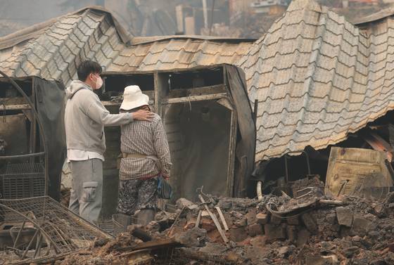People look upon the ruins of a house in Yeongyang County, North Gyeongsang, on March 26, a day after it was destroyed by the ongoing wildfires in southeastern Korea. [NEWS1]