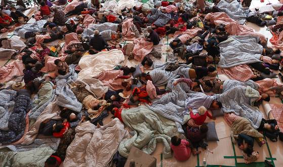 Residents of Yeongyang County, North Gyeongsang, who were evacuated from the path of an ongoing wildfire rest at the local government-run shelter on March 26. [YONHAP]