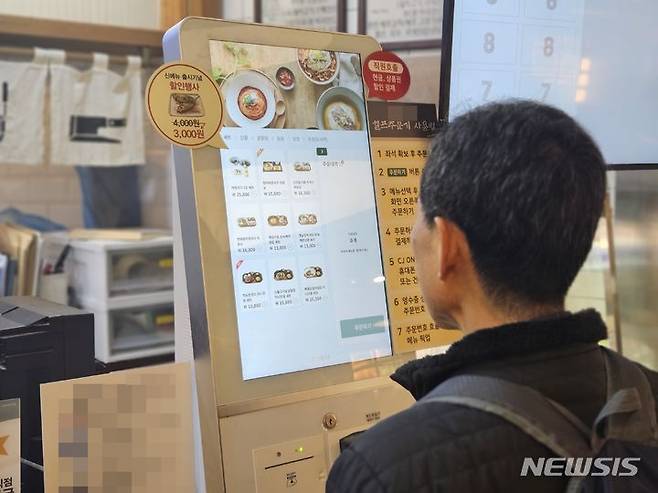 [서울=뉴시스] 이태성 기자 = 16일 서울 동대문구 전농동의 한 식당에서 시민이 무인 안내기(키오스크)로 음식을 주문하고 있다. 2024.01.16. victory@newsis.com *재판매 및 DB 금지