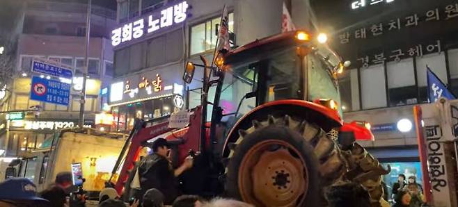 [서울=뉴시스] 26일 오후 10시10분께 서울 종로구 효자동 자하문로에 견인돼 있던 전농 트랙터 1대가 시민들과 함께 행진한 뒤 떠나고 있다.(사진=최은수 기자) *재판매 및 DB 금지