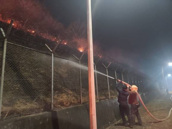 산불 확산 막는 교도소 직원들 - 지난 25일 경북 청송군 경북북부 제2교도소에서 교도소 인근까지 번진 산불을 막기 위해 직원들이 물을 뿌리고 있다. 2025.3.26  법무부 교정본부 제공.