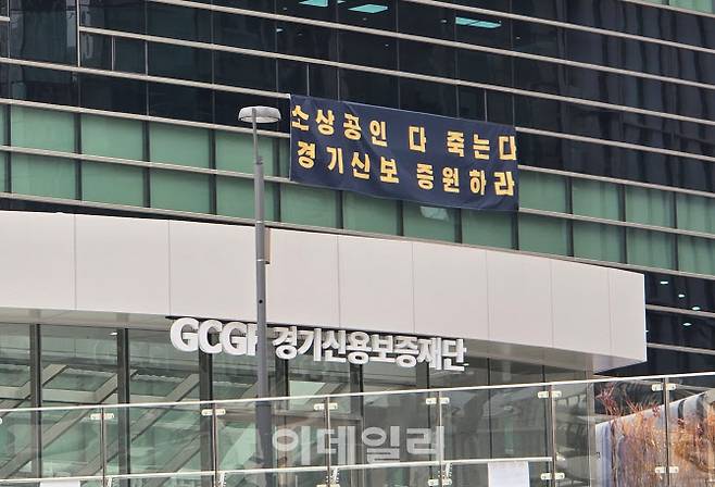 26일 경기신용보증재단 광교 신사옥 외벽에 걸린 현수막 모습.(사진=황영민 기자)