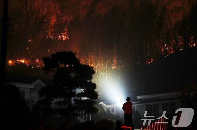 경남 산청 대형 산불 닷새째인 25일 오후 산청군 시천면 일대에서 민가 뒤로 불길이 치솟고 있다. 2025.3.25/뉴스1 ⓒ News1 윤일지 기자