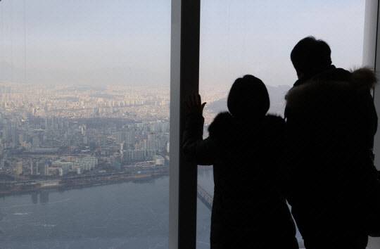 도심 아파트 밀집 지역을 바라보는 시민들.<연합뉴스>