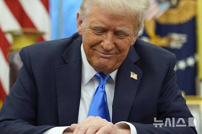 [워싱턴=AP/뉴시스] 도널드 트럼프 미국 대통령이 지난 2월 11일(현지 시간) 워싱턴DC 백악관 집무실에서 일론 머스크가 발언하는 걸 들으며 미소 짓고 있다. 2025.03.27.