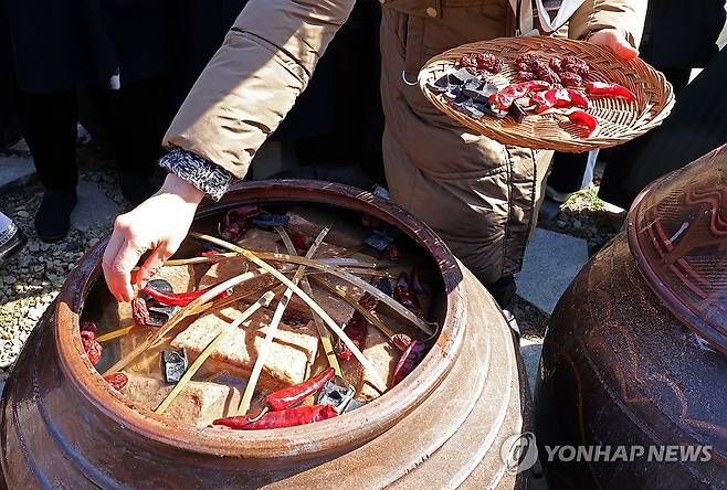 정월 장 담그기 (담양=연합뉴스) 조남수 기자 = 18일 전남 담양군 기순도 장고(醬庫)에서 열린 유네스코 인류무형문화유산 '한국의 장담그기' 등재 기념 기순도 명인과 함께하는 정월 장(醬) 담그기에서 참석자가 장 담기 체험하고 있다. 2025.2.18 iso64@yna.co.kr