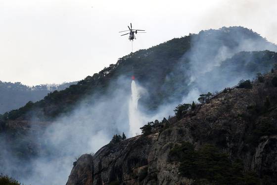 27일 경북 청송군 주왕산면 상의리 주왕산 국립공원 산불 현장에 투입된 헬기가 산불 진화를 위해 물을 뿌리고 있다. 뉴스1