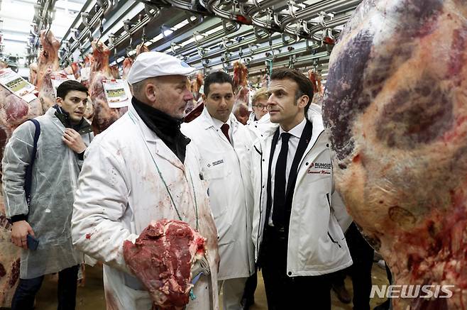 [헝지스=AP/뉴시스] 에마뉘엘 마크롱 프랑스 대통령이 파리 남부 헝지스에 있는 국제 식품도매시장을 찾아 상인들과 얘기하고 있다. 자료사진. 2025.03.28