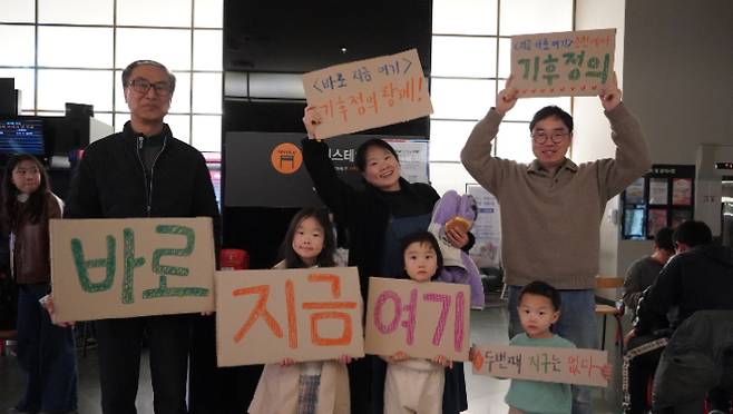 '바로 지금 여기' 영화 시사회에 참석한 가족들이 피켓을 들고 있다. 주최 측 제공
