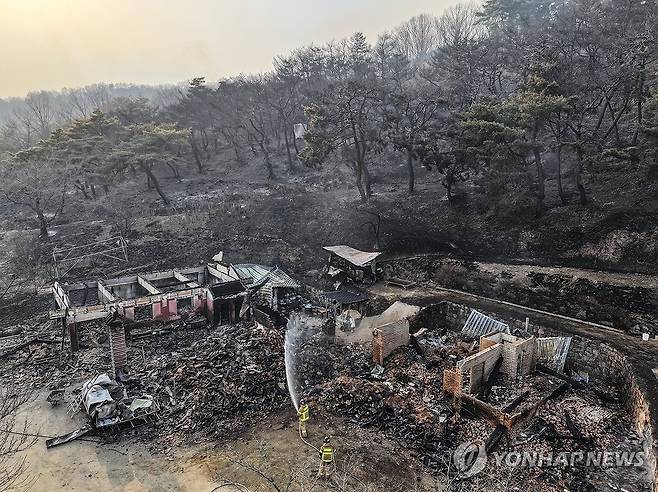 산불이 할퀴고 간 사찰 (의성=연합뉴스) 윤관식 기자 = 경북 의성군 대형 산불 발생 이틀째인 지난 23일 의성군 안평면 신안리 운람사와 인근 산림이 산불에 폐허가 된 가운데 소방대원이 잔불 진화작업을 하고 있다. 2025.3.28 psik@yna.co.kr