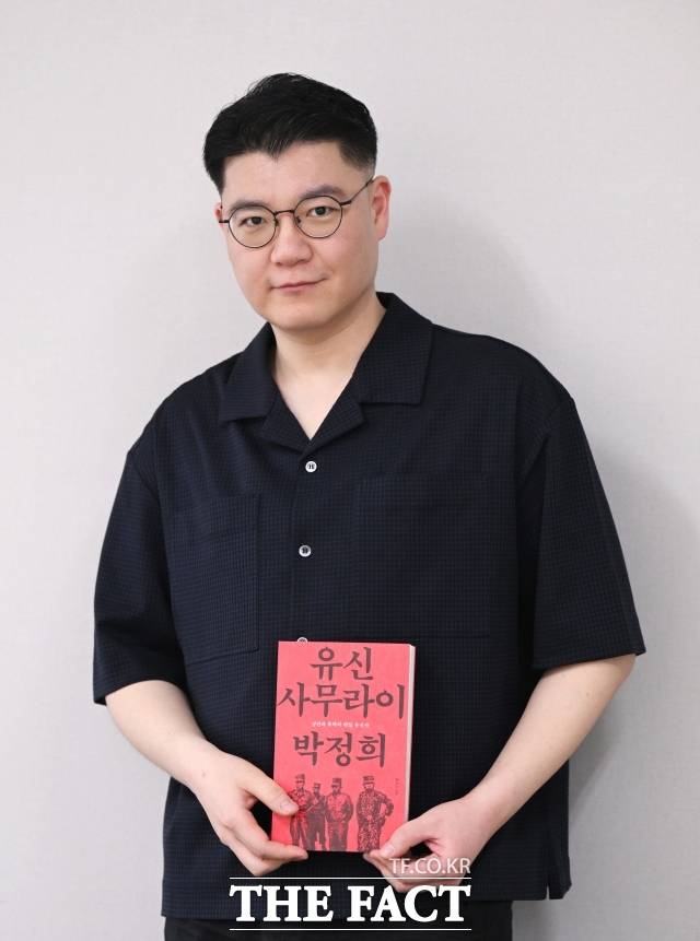 홍대선 작가가 25일 오후 서울 마포구 상암동 <더팩트> 사무실에서 인터뷰하며 자신의 저서 '유신 사무라이 박정희' 책을 들어보이고 있다. /이새롬 기자