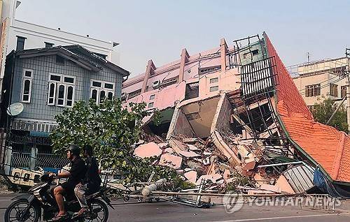 만달레이 거리의 모습 (미얀마 만달레이 AFP=연합뉴스) 2025년 3월 28일 강진으로 건물들이 무너진 미얀마 만달레이의 거리를 사람들이 오토바이로 지나가고 있다. (Photo by AFP) 2025.3.29.
