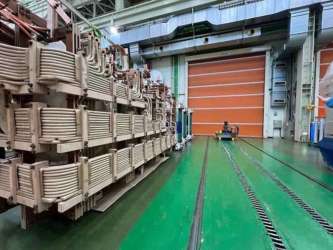 LS일렉트릭 부산사업장 1생산동 내 주황색 문이 내려온 진공건조로(VPD·Vapor Phase Drying) 앞에 제작 중인 변압기가 놓여져 있다./김남희 기자