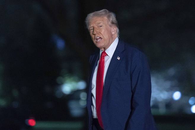 도널드 트럼프 미국 대통령이 30일(현지시간) 백악관 잔디밭을 걸으며 기자들과 이야기를 나누고 있다. AP연합뉴스