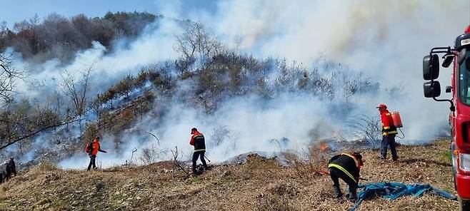 [영동=뉴시스] 26일 오전 10시6분께 소방당국에 신고된 충북 영동군 황간면 소계리 산불 발생 현장에서 영동소방서 대원들과 영동군 산불감시원들이 진압작업을 벌이고 있다. 소방당국은 주변 과수원에서 농업 부산물을 소각하는 과정에서 불이 옮겨붙은 것으로 추정하고 있다. (사진=영동소방서 제공) 2025.03.26. photo.newsis.com *재판매 및 DB 금지
