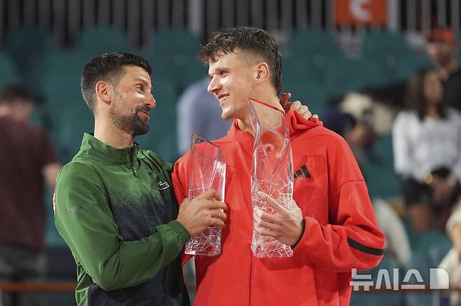 [마이애미=AP/뉴시스] 야쿱 멘식(54위·체코)이 30일(현지 시간) 미 플로리다주 마이애미가든에서 열린 남자프로테니스(ATP) 마이애미 오픈 단식 결승에서 승리한 뒤 노바크 조코비치(5위·세르비아)와 대화하고 있다. 올해 19세인 멘식은 투어 레벨 통산 100승을 노리던 조코비치를 2-0(7-6 7-6)으로 꺾고 정상에 올랐다. 2025.03.31.