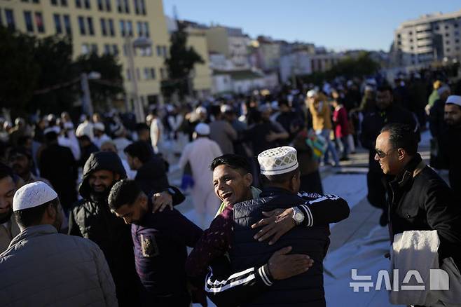 [리스본=AP/뉴시스] 30일(현지 시간) 포르투갈 리스본의 광장에서 이드 알피트르 기도를 마친 무슬림들이 라마단 성월의 끝을 축하하며 서로 얼싸안고 있다. 2025.03.31.
