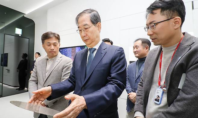 한덕수 대통령 권한대행 국무총리가 31일 경기도 SK하이닉스 이천캠퍼스 수펙스(SUPEX)센터에서 곽노정 SK하이닉스 대표이사 사장의 설명을 들으며 메모리반도체 생산 Fab인 'M14 윈도우 투어'를 하고 있다. SK하이닉스 제공