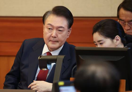 윤석열 대통령이 지난 2월 13일 서울 종로구 헌법재판소에서 열린 탄핵심판 8차 변론에서 변호인단과 대화하고 있다. 〈사진=공동취재단〉