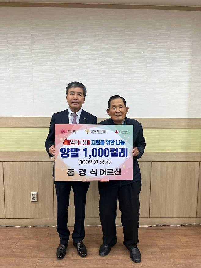 지난달 31일 전북 전주시 복지재단을 찾은 홍경식 씨(오른쪽)가 산불 피해 주민을 돕기 위해 양말 1000켤레를 기부한 것을 기념해 윤방섭 이사장과 사진을 찍고 있다. 전주시 제공