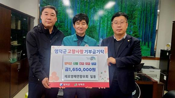 1일 신현기 재포영해면향우회장(오른쪽)이 산불 피해 고향 주민들을 위해 기부금을 전달하고 있다.  [사진=재포영해면향우회]