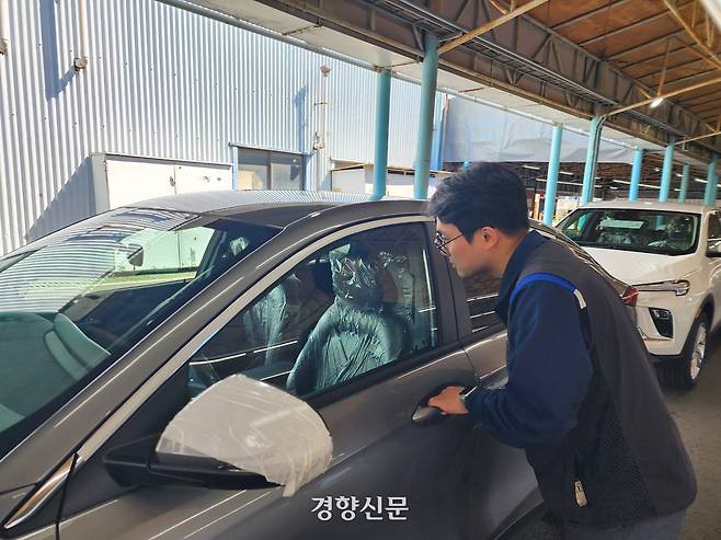 한국GM 용역업체 비정규직 직원 이모씨가 28일 인천 한국GM 부평공장에서 마무리 청소작업을 기다리는 완성차를 바라보고 있다. 김세훈 기자.