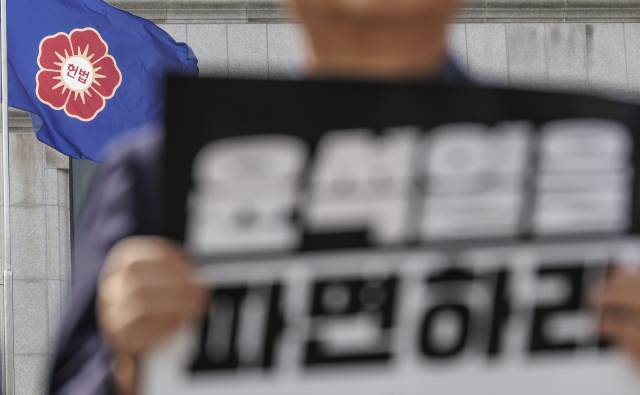 ▲ 3월 24일 서울 종로구 헌법재판소 정문 앞에서 열린 헌재의 윤석열 대통령 탄핵 심판 선고 기일 신속 지정 촉구 소추단 기자회견 도중 헌재 깃발이 펄럭이고 있다. ⓒ연합뉴스