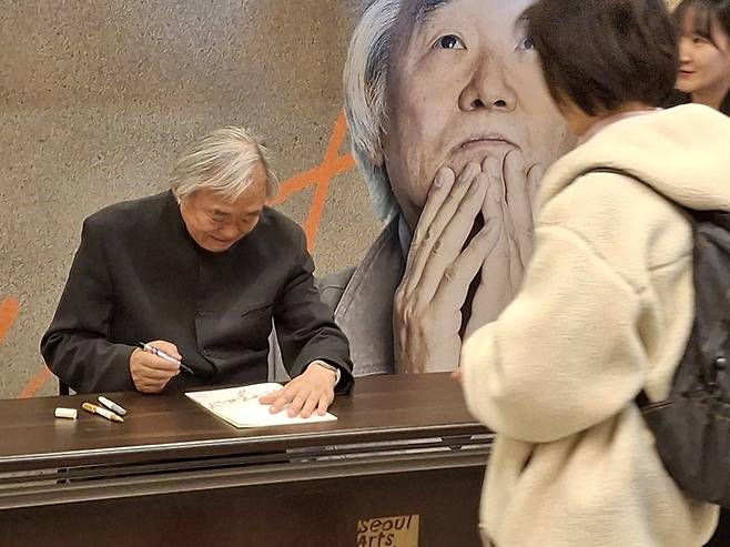 관객들과 사인회에 응하며 소통하고 있는 피아니스트 백건우. (사진 공연기획사 판테온)